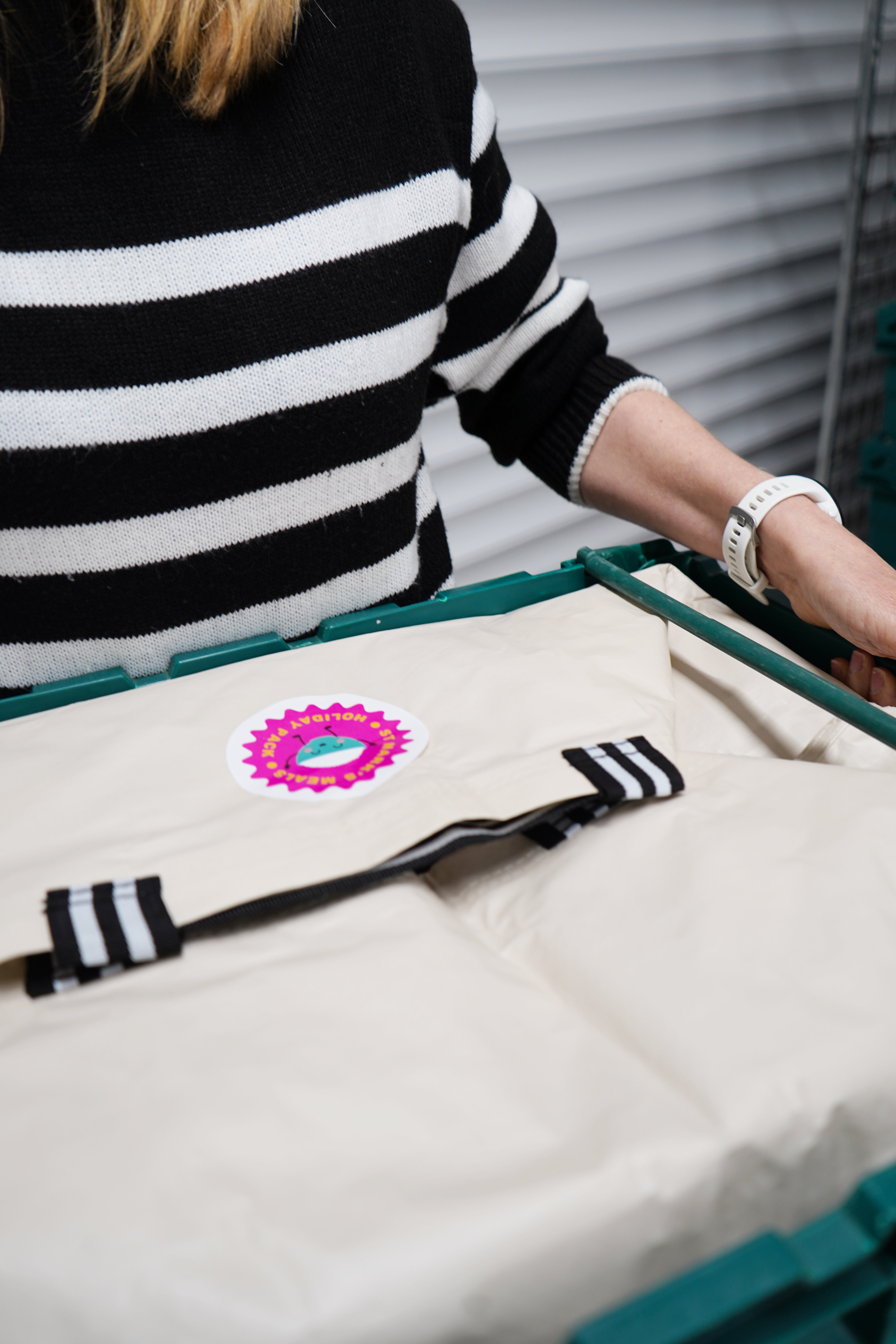 Woman carrying holiday pack of food in crate.